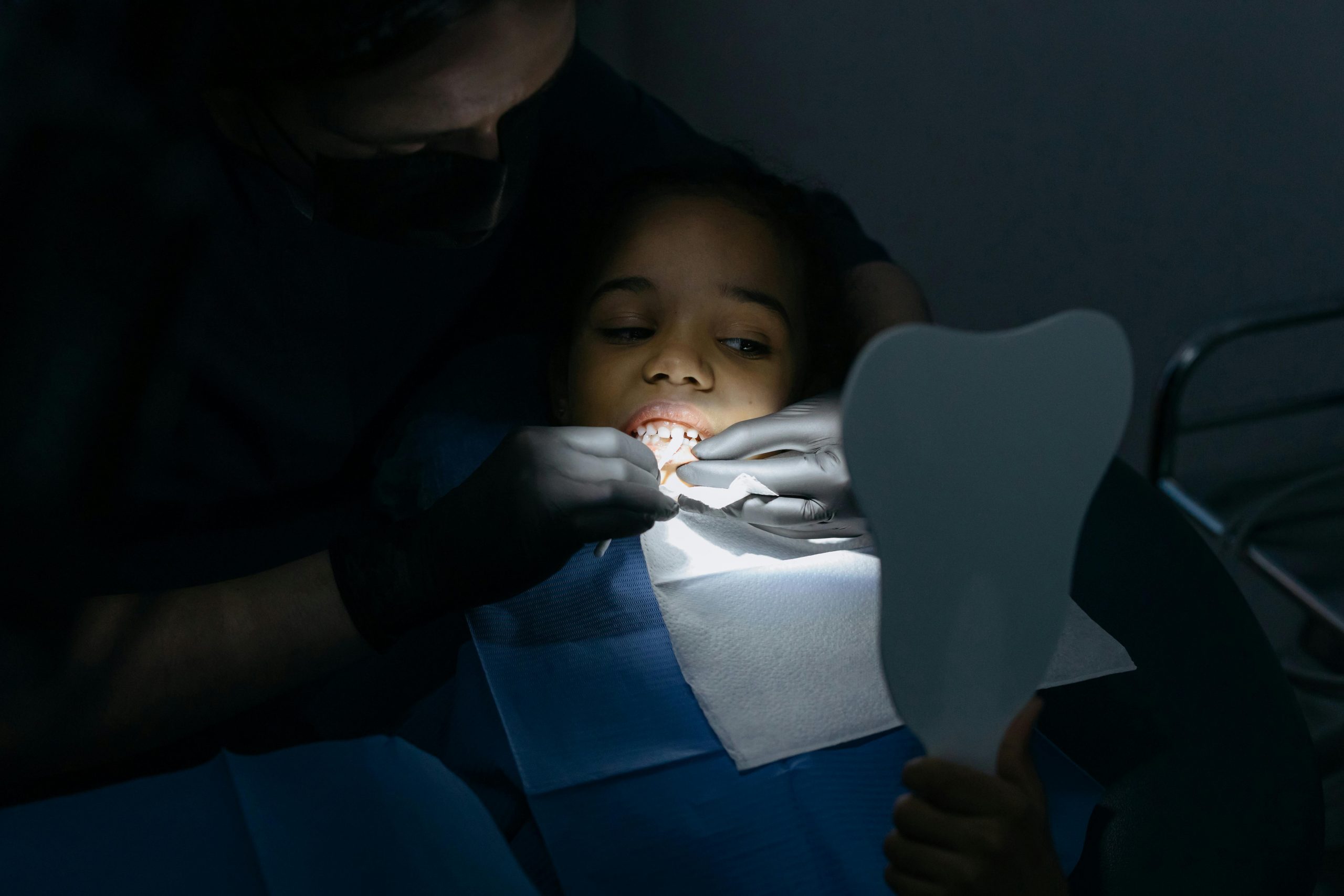 A child receives a dental checkup at a clinic, highlighting oral health care.